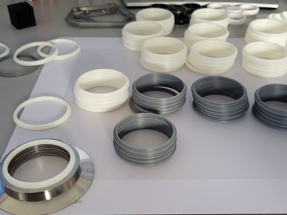 Serie gedruckter Blockringe in Weiß und Grau neben einem Metallteil