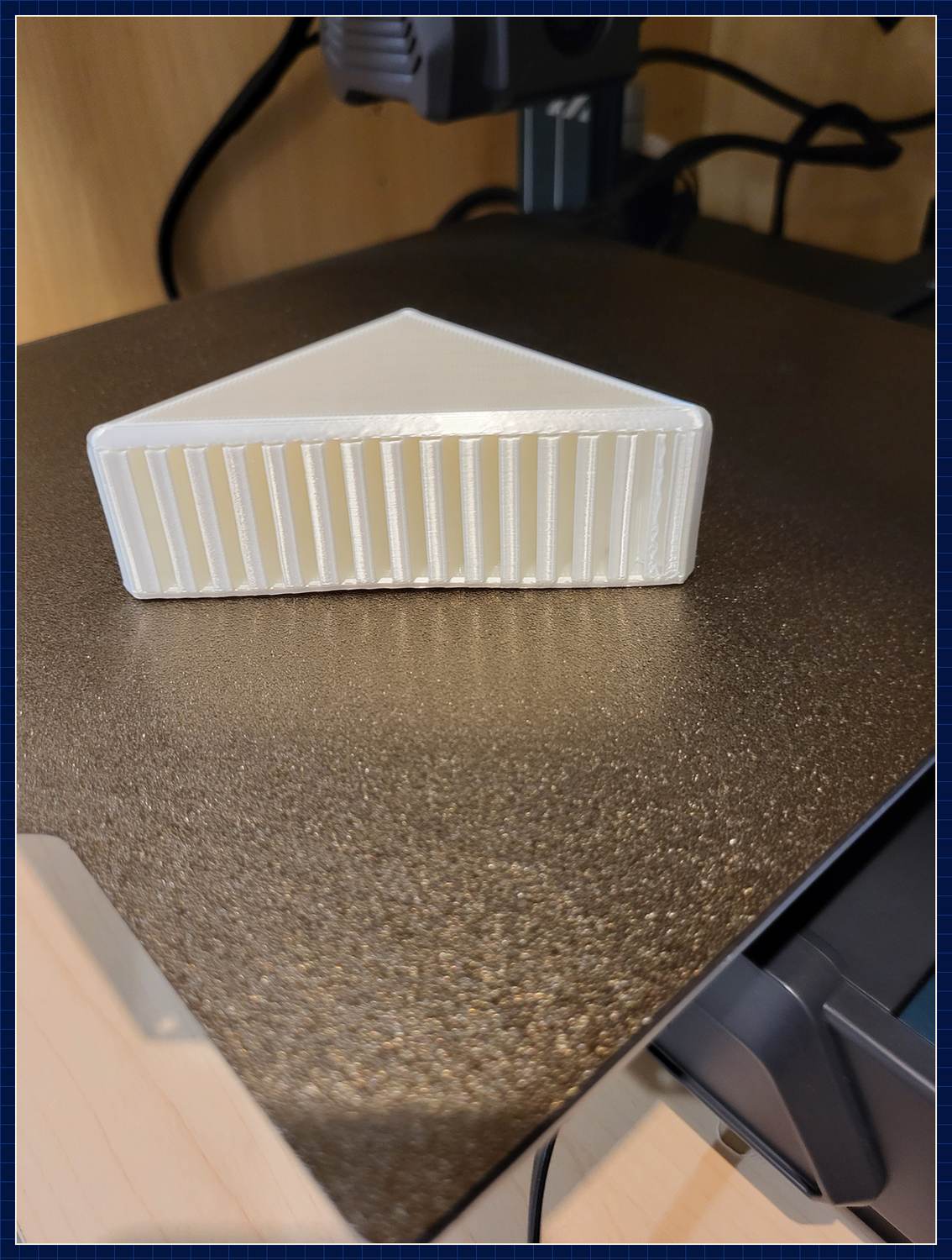 Gedrucktes weißes Bauteil mit Rippenstruktur auf dem Druckbett